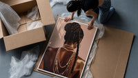 Black Woman with a Braided Bun framed print being unpacked from protective bubble wrap and a box