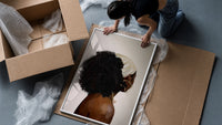 Black Woman with a Curly Puff framed print being unpacked from protective bubble wrap and a box