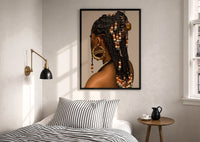 Black Woman with Beaded Braids print in a black frame above a bed with striped linens, a brass wall lamp and a sunlit window