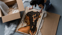 Black Woman with Beaded Braids framed print being unpacked from protective bubble wrap and a box