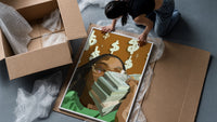 Black Woman with Cash framed print being unpacked from protective bubble wrap and a box