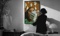 Black Woman with Cash print in a slim black frame being hung on a sunlit wall in a monochrome room
