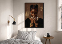 Black Woman with Clasped Hands print in a black frame above a bed with striped linens, a brass wall lamp and a sunlit window