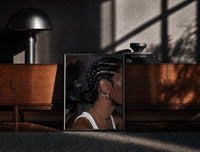 Black-framed Black Woman with Cornrow Braids print on the floor in front of a dark wooden console