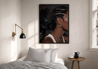 Black Woman with Cornrow Braids print in a black frame above a bed with striped linens, a brass wall lamp and a sunlit window