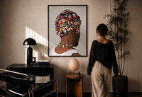 Bottle Cap Headpiece and Chunky Necklaces print in a black frame on a sunlit wall with a viewer