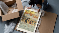 Woman and children wading at beach framed print being unpacked from protective bubble wrap and a box