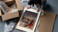 Woman in traditional dress by seaside framed print being unpacked from protective bubble wrap and a box
