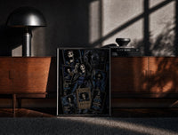Black-framed Skeleton musician in top hat print on a moody console with designer coffee-table books