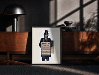 Black-framed Monkey in top hat and suit print on a moody console with designer coffee-table books