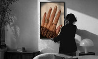 Brown Almond Nails print in a slim black frame being hung on a sunlit wall in a monochrome room