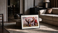 Two children washing a dog print in a slim black frame leaning on a travertine coffee table