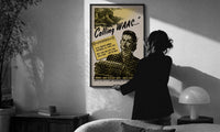 Calling WAAC print in a slim black frame being hung on a sunlit wall in a monochrome room