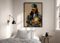 Camo Jacket and Takeaway Drink print in a black frame above a bed with striped linens, a brass wall lamp and a sunlit window