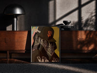 Black-framed Cap and Paisley Bandana print on the floor in front of a dark wooden console
