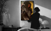 Cap and Paisley Bandana print in a slim black frame being hung on a sunlit wall in a monochrome room