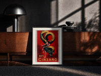 Black-framed Woman dancing with champagne bottle print on a moody console with designer coffee-table books