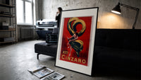 Woman dancing with champagne bottle print in a slim black frame leaning on a dark sofa in a concrete print studio