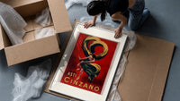 Woman dancing with champagne bottle framed print being unpacked from protective bubble wrap and a box