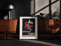 Black-framed Woman in green riding red horse print on a moody console with designer coffee-table books