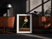 Black-framed Fire-breathing man clutching cotton wool print on a moody console with designer coffee-table books