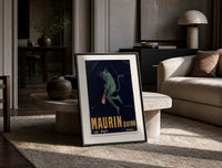 Green devil holding aperitif bottle print in a black frame leaning on a travertine table in a sunlit lounge