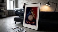Two figures atop a pocket watch print in a slim black frame leaning on a dark sofa in a concrete print studio