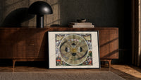 Copernican solar system celestial map print in a black frame leaning against a walnut console in lamplight