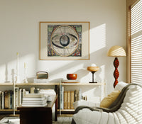 Ptolemaic celestial sphere armillary map print in an oak frame above a mid-century book console with a vintage radio