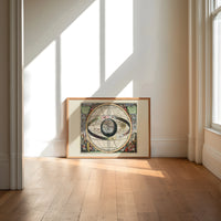 Ptolemaic celestial sphere armillary map print in an oak frame on a sunlit wood floor beneath tall window light