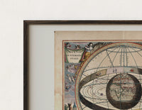 Close-up of the Ptolemaic celestial system with globe print's dark wood frame corner and archival matte paper