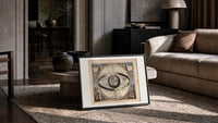Ptolemaic celestial system with globe print in a slim black frame leaning on a travertine coffee table