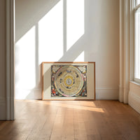 Ptolemaic celestial map of universe print in an oak frame on a sunlit wood floor beneath tall window light