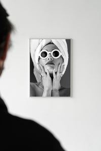 Framed editorial black and white portrait featuring round white sunglasses and statement diamond jewellery