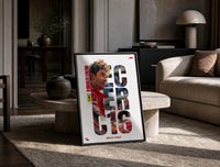 Charles Leclerc F1 driver portrait print in a black frame leaning on a travertine table in a sunlit lounge