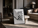 Hand waving checkered racing flag print in a black frame leaning on a travertine table in a sunlit lounge