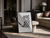 Hand waving checkered racing flag print in a black frame leaning on a travertine table in a sunlit lounge