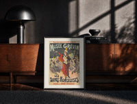 Black-framed Female conductor leading violin orchestra print on a moody console with designer coffee-table books