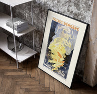 Woman dancing in flames poster in a black frame leaning beside a shelf in a raw-plaster loft