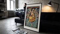 Dancing woman on trapeze print in a slim black frame leaning on a dark sofa in a concrete print studio