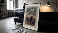 Gypsy musicians playing violin print in a slim black frame leaning on a dark sofa in a concrete print studio