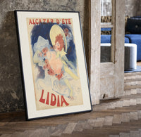 Woman in yellow hat with roses print in a black frame leaning beside a vintage door on parquet
