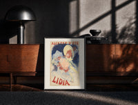 Black-framed Woman in yellow hat with roses print on a moody console with designer coffee-table books