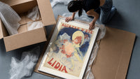 Woman in yellow hat with roses framed print being unpacked from protective bubble wrap and a box