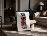 Woman ice skating in red dress print in a black frame leaning on a travertine table in a sunlit lounge