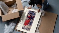 Woman ice skating in red dress framed print being unpacked from protective bubble wrap and a box