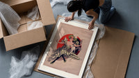 Woman with wine glass and cat framed print being unpacked from protective bubble wrap and a box
