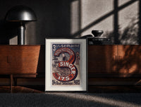 Black-framed Woman using Singer sewing machine print on a moody console with designer coffee-table books