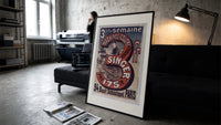 Woman using Singer sewing machine print in a slim black frame leaning on a dark sofa in a concrete print studio