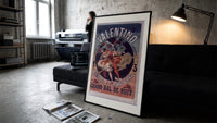 Costumed dancers at masquerade ball print in a slim black frame leaning on a dark sofa in a concrete print studio